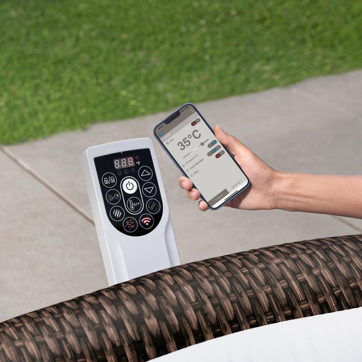 Dłoń trzymająca smartfon obok panelu sterowania pompy jacuzzi ustawionej na trawie. Panel posiada cyfrowy wyświetlacz oraz przyciski funkcyjne, w tym ikonę Wi-Fi.